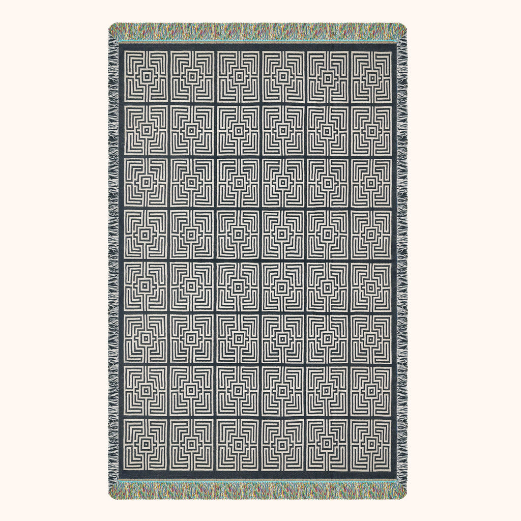 Patterned woven blanket with geometric design; black and ivory.